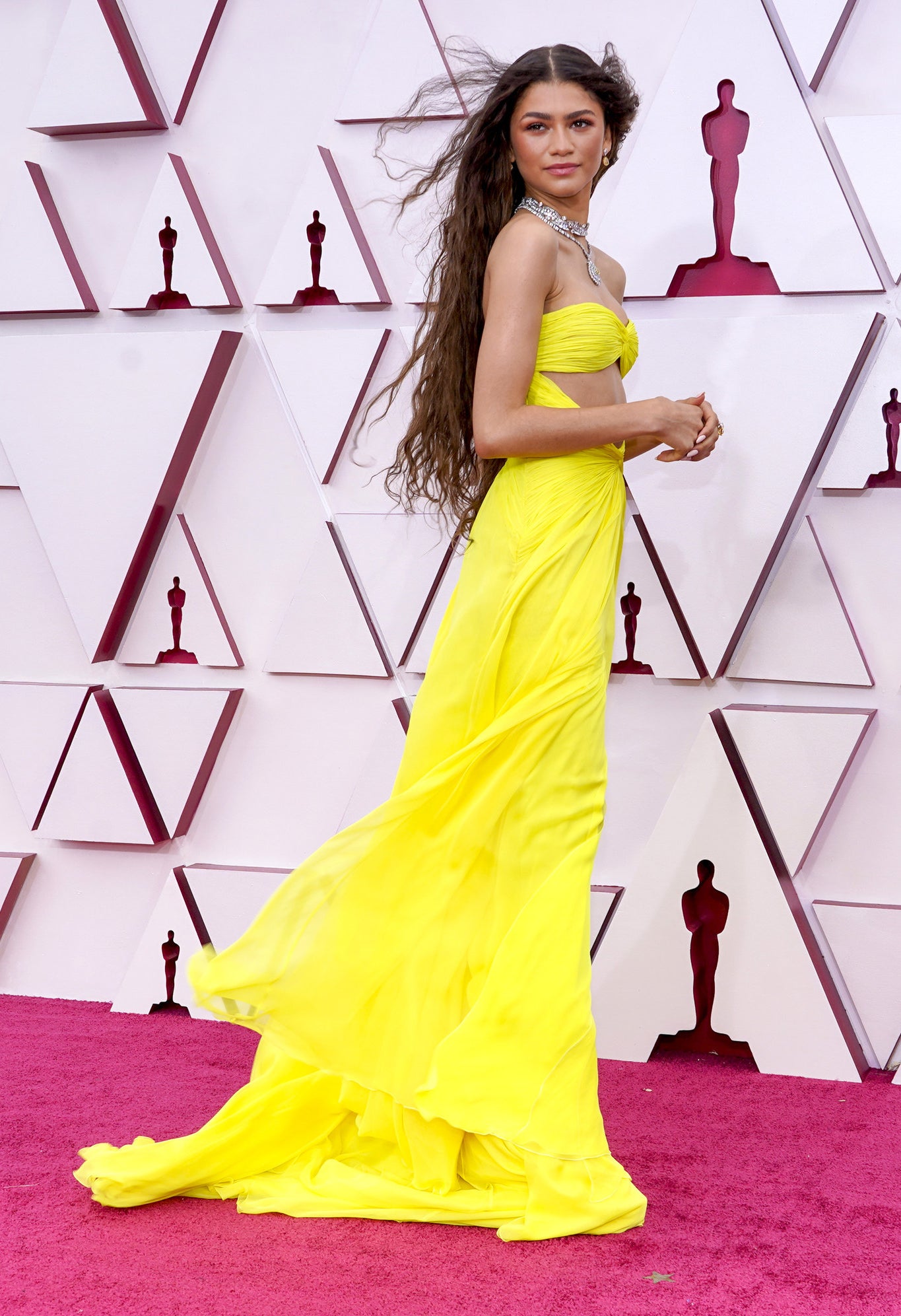 Zendaya wearing a bright yellow gown and her hair flowing