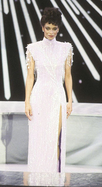 Debbie wearing a pink flapper gown with large shoulders