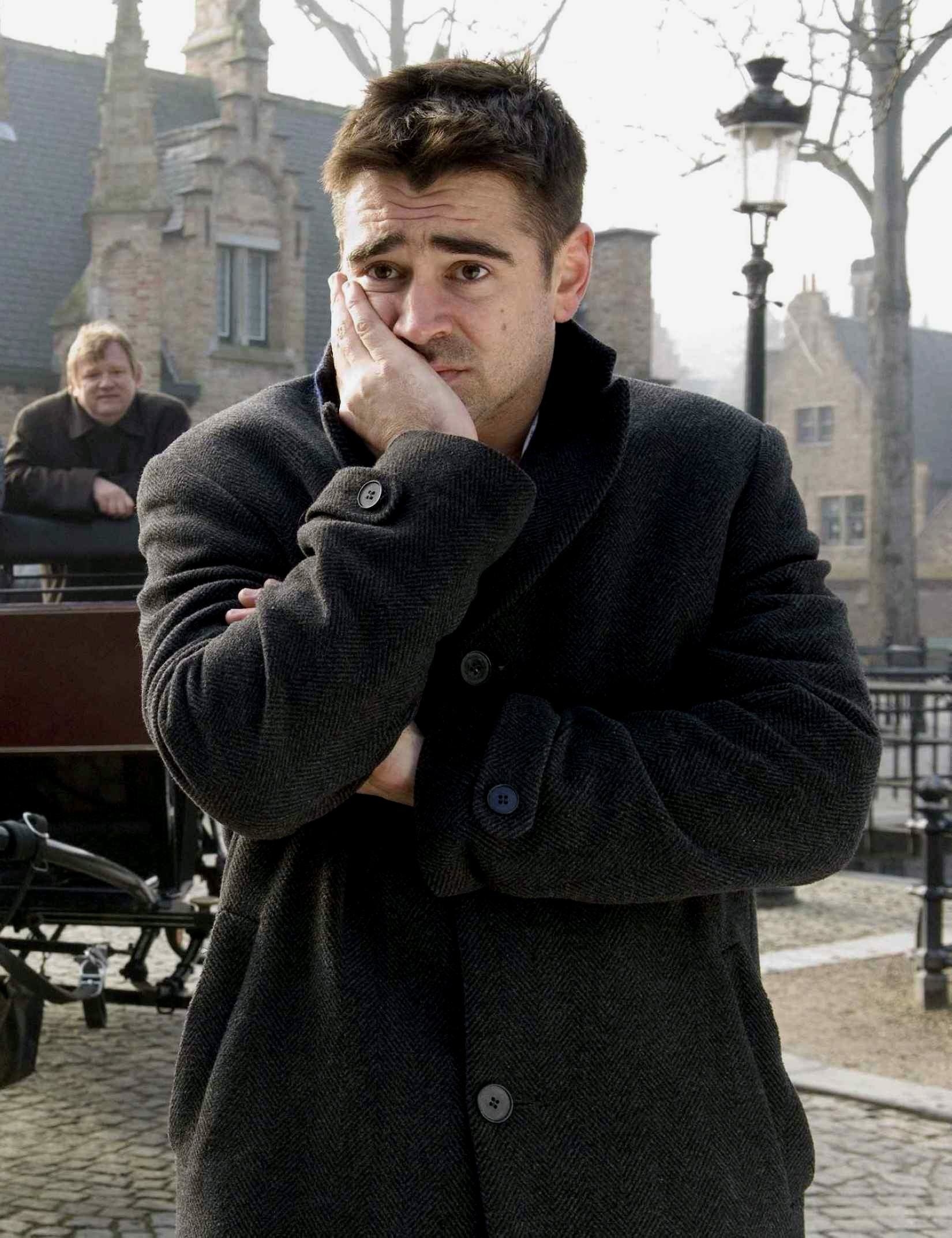 Colin Farrell stands with his right hand covering half of his mouth and all of his cheek