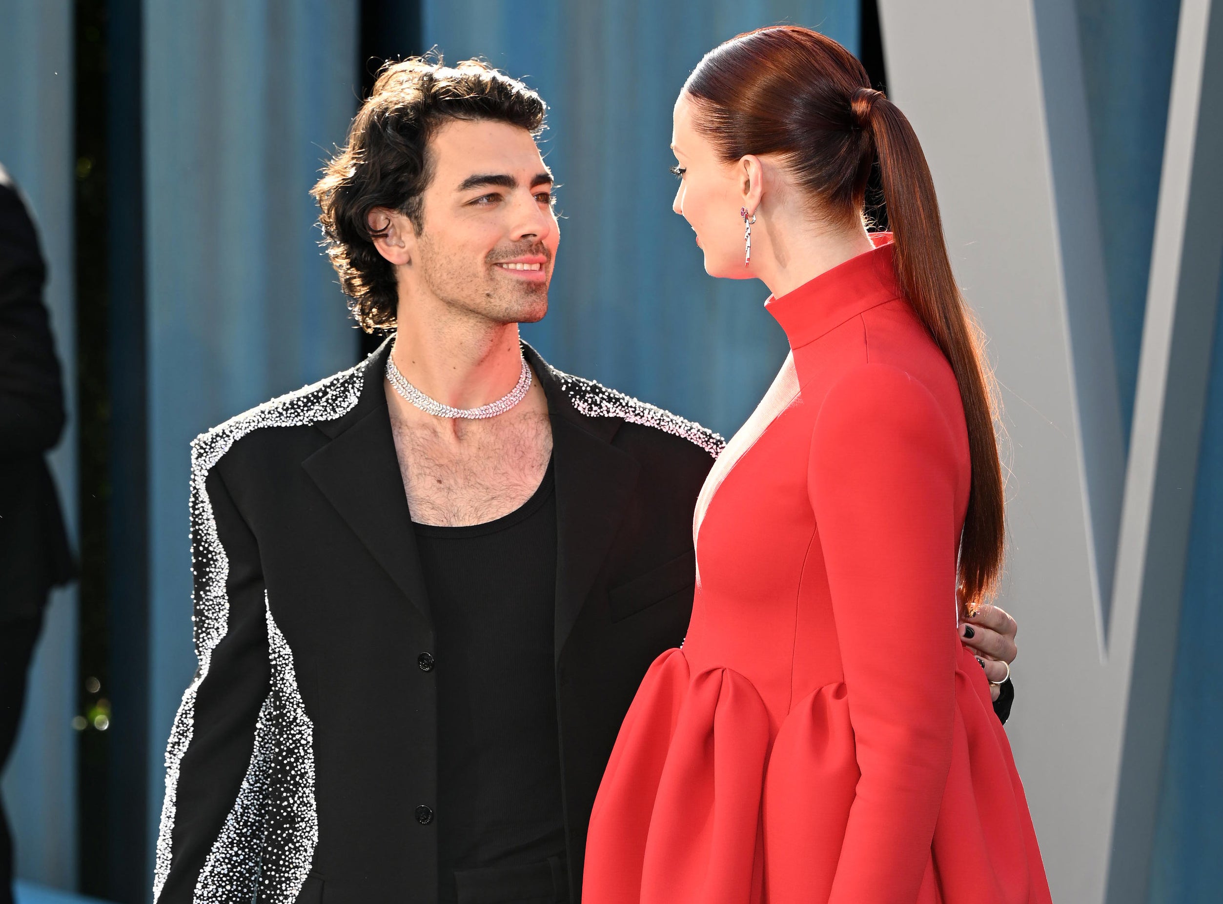 Joe looks at Sophie and smiles in the same outfit
