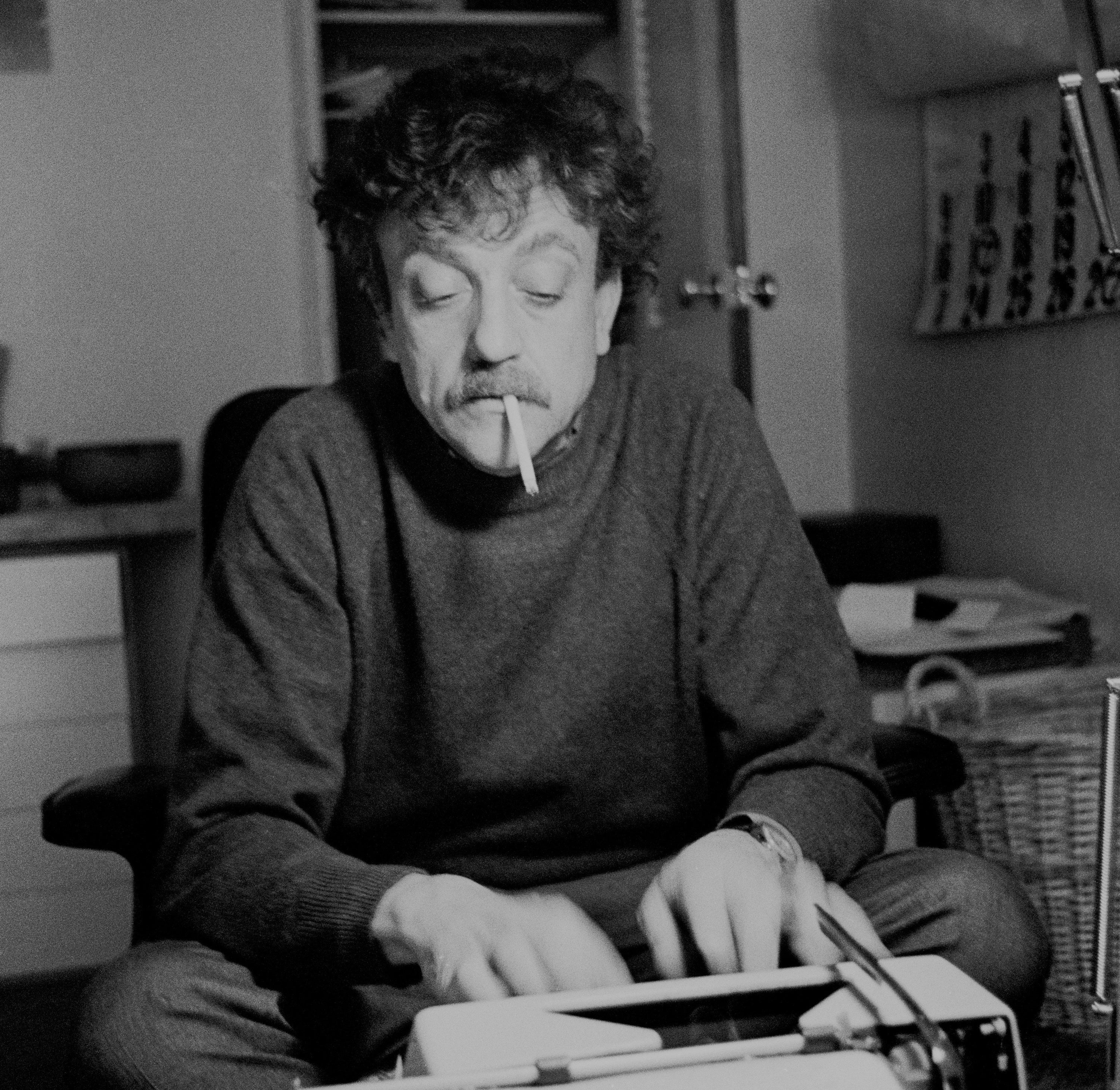 Kurt Vonnegut smoking and writing at a type writer