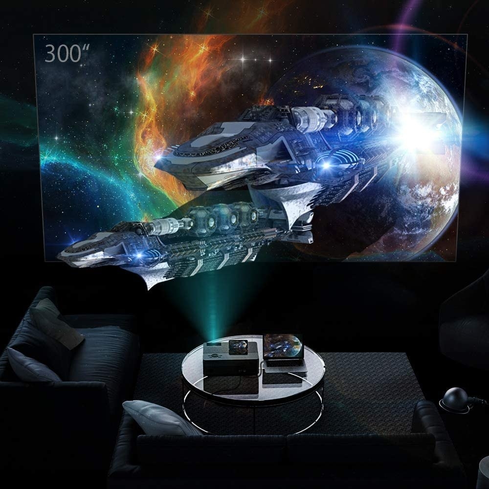 the video projector with space-themed film on wall in front of couch area
