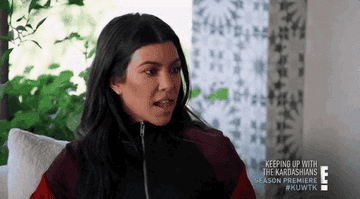 Kourtney looks annoyed as she shrugs with her tongue on her lip