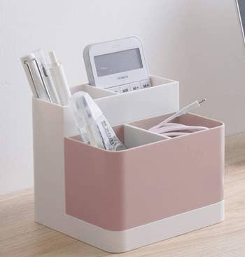 the pink organizer holding office supplies on a desk