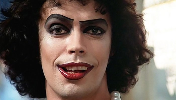 Tim Curry as Dr Frank-N-Furter raising his eyebrows with a sly smirk in The Rocky Horror Picture Show