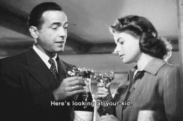 Humphrey Bogart saying to Ingrid Bergman in Casablanca, &quot;Here&#x27;s looking at you, kid,&quot; as each of them holds a champagne coupe glass