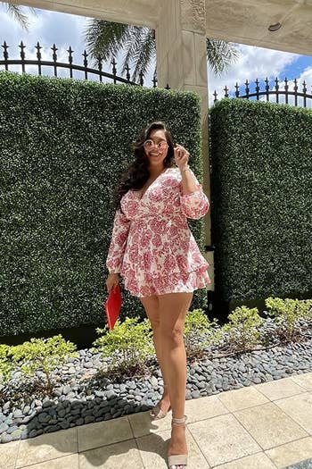 a reviewer wearing the red and white floral romper