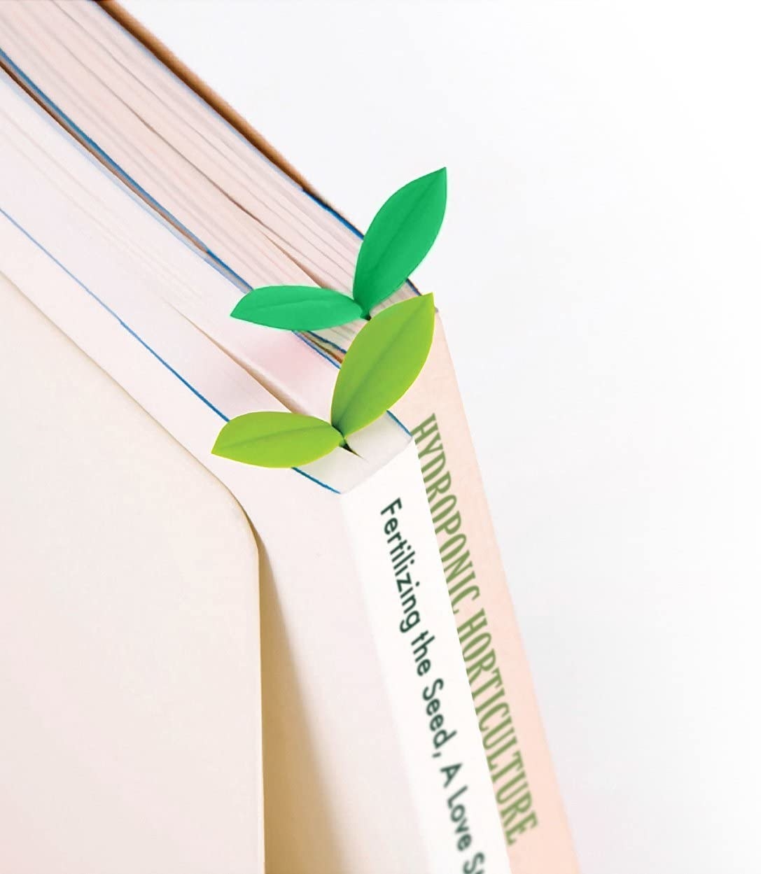 A set of small sprout bookmarks peeking out of books