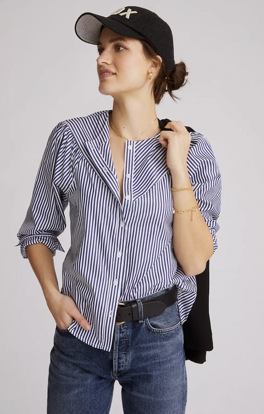 a person wearing the blue and white striped button down with a hat and jeans