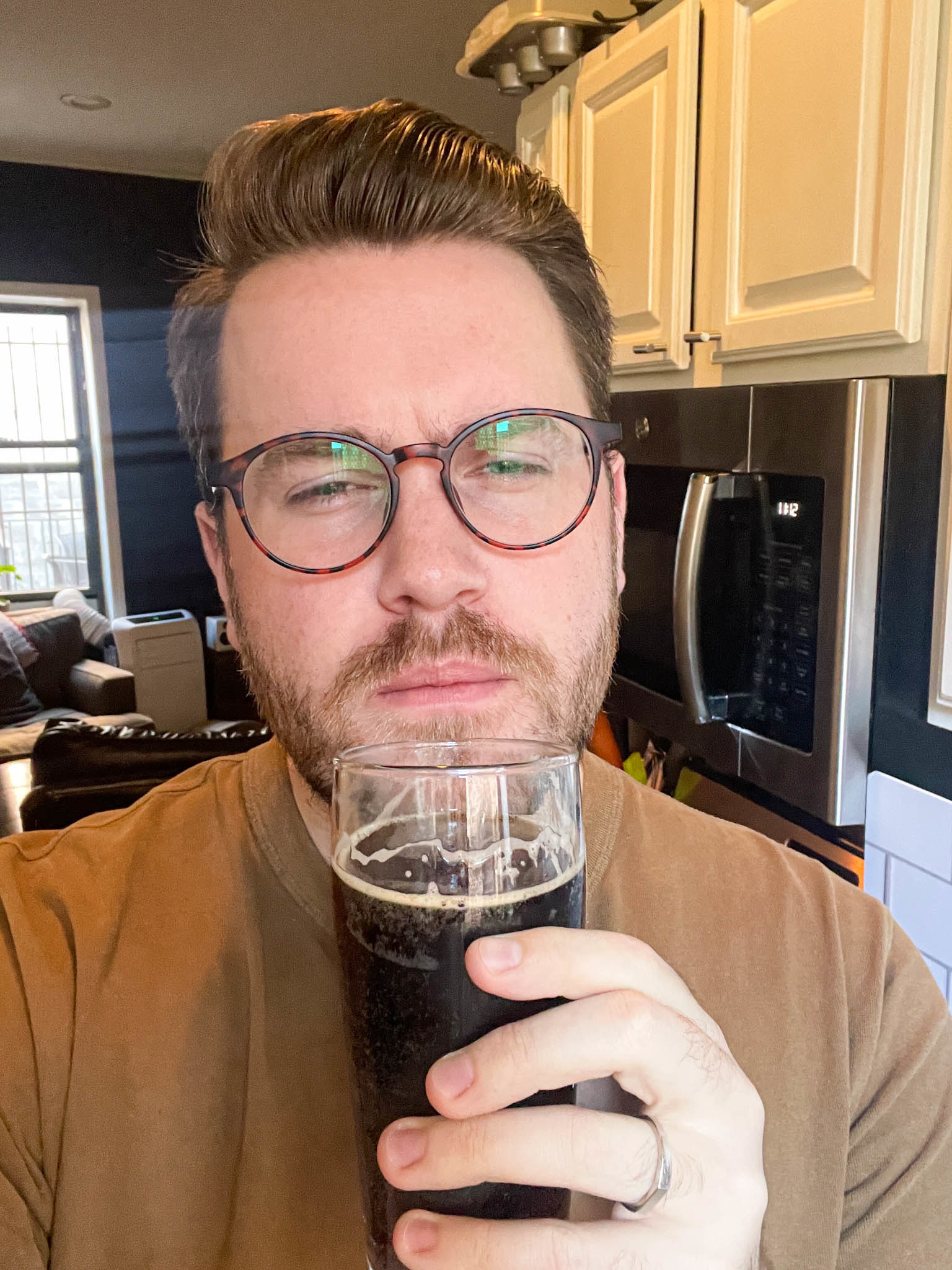 Author making a puzzled face while holding up a glass of Nitro Pepsi