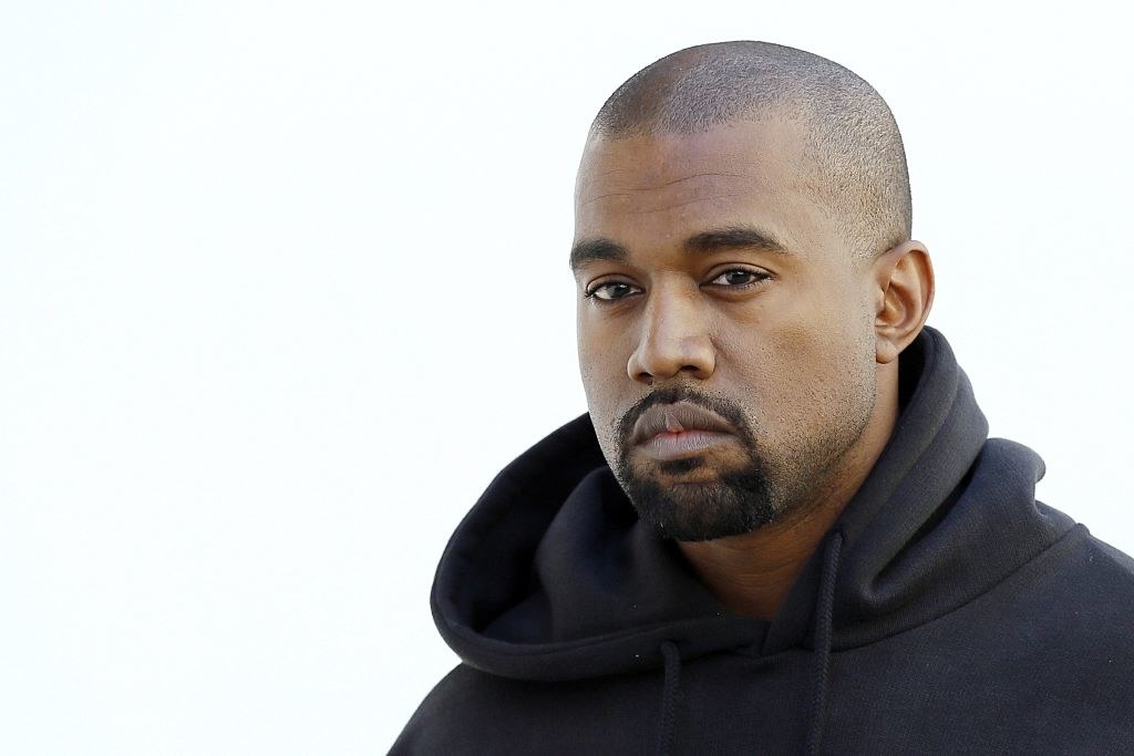 A closeup of icon Kanye West wearing a hoodie