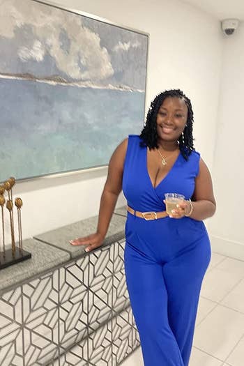 a reviewer in a royal blue jumpsuit