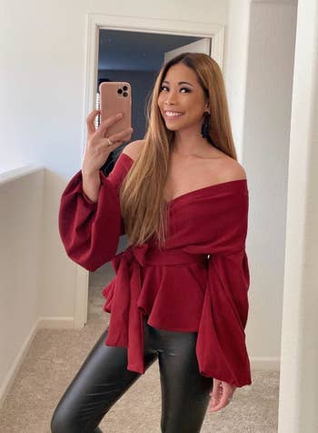 a reviewer poses for a mirror selfie in the red top