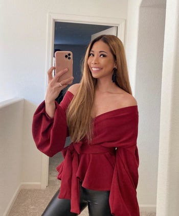 a reviewer poses for a mirror selfie in the red top