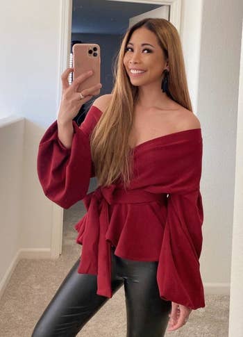 a reviewer poses for a mirror selfie in the red top