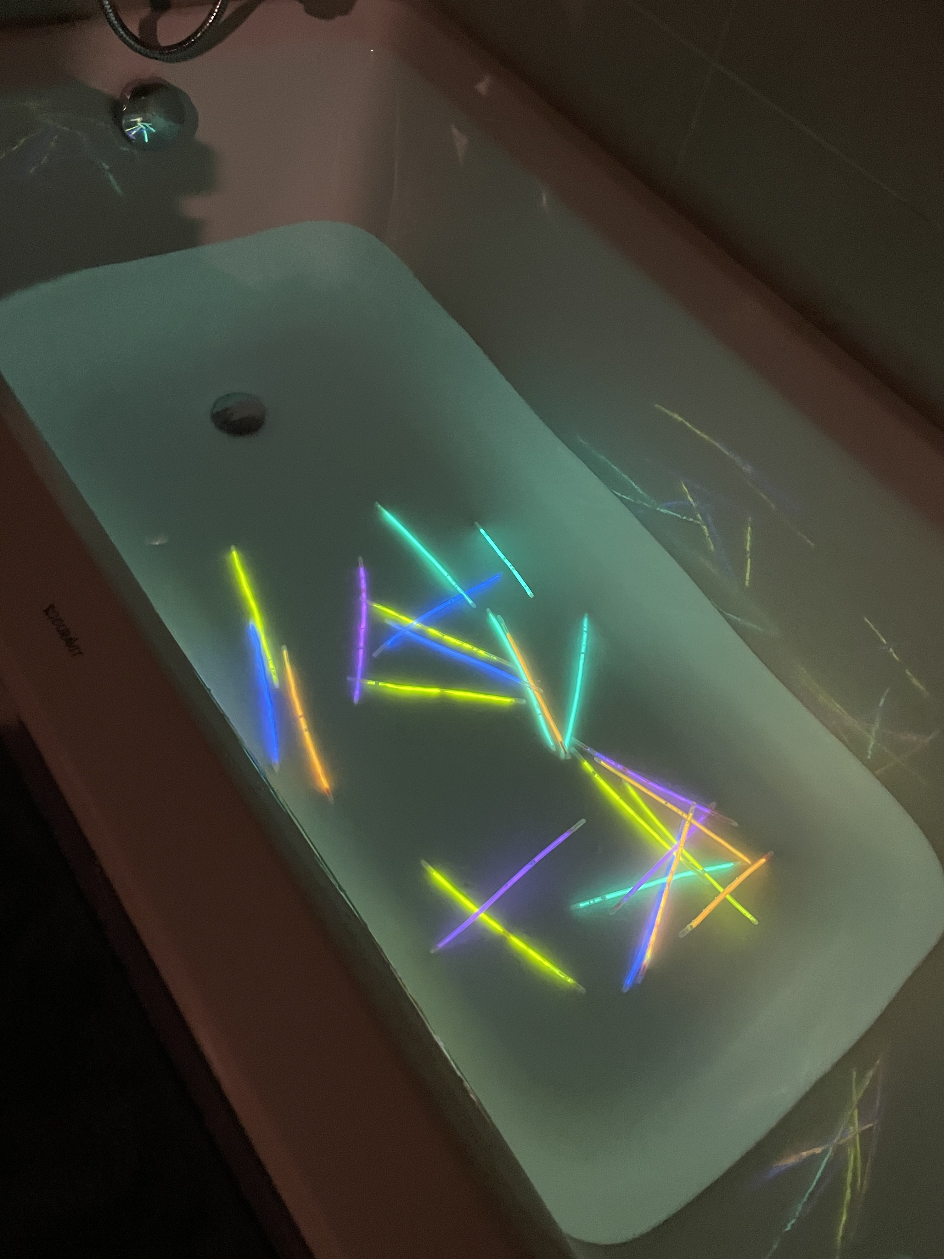 A tub filled with water and about 25 glow sticks