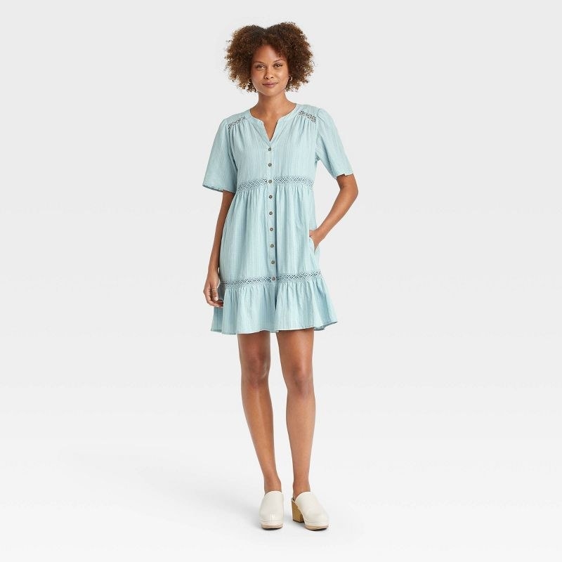 model wearing baby blue dress with vertical knit design, stops mid thigh