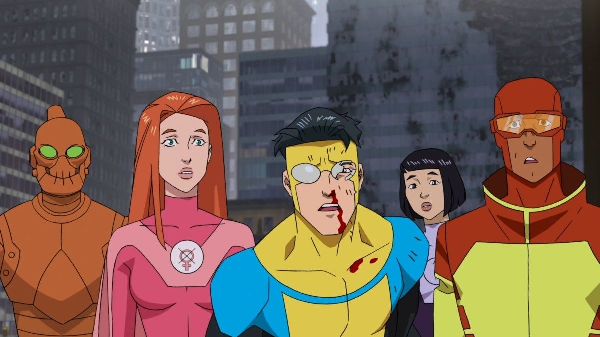 Robot, Atom Eve, Invincible, Dupli-Kate and Rex Splode in front of some grey buildings. One of Invincible&#x27;s goggles is broken and blood runs down from his nose.