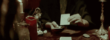 A person putting a tarot card on a table