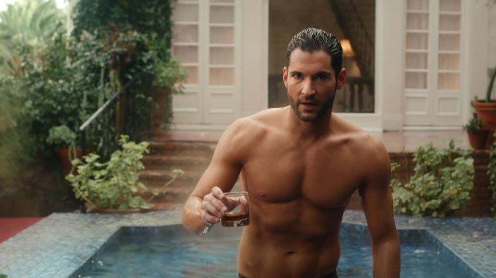 Lucifer emerging from a pool shirtless, holding a drink