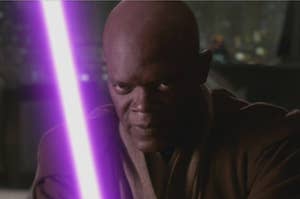 A close up of Mace Windeu as he wields his lightsaber close to his face