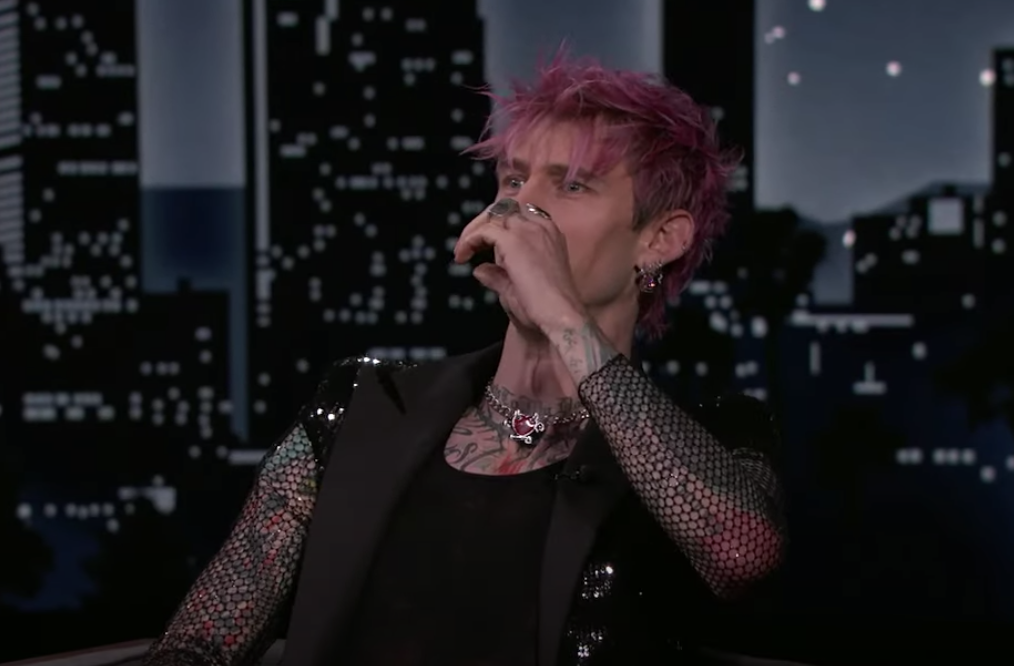 MGK mimics taking a drink