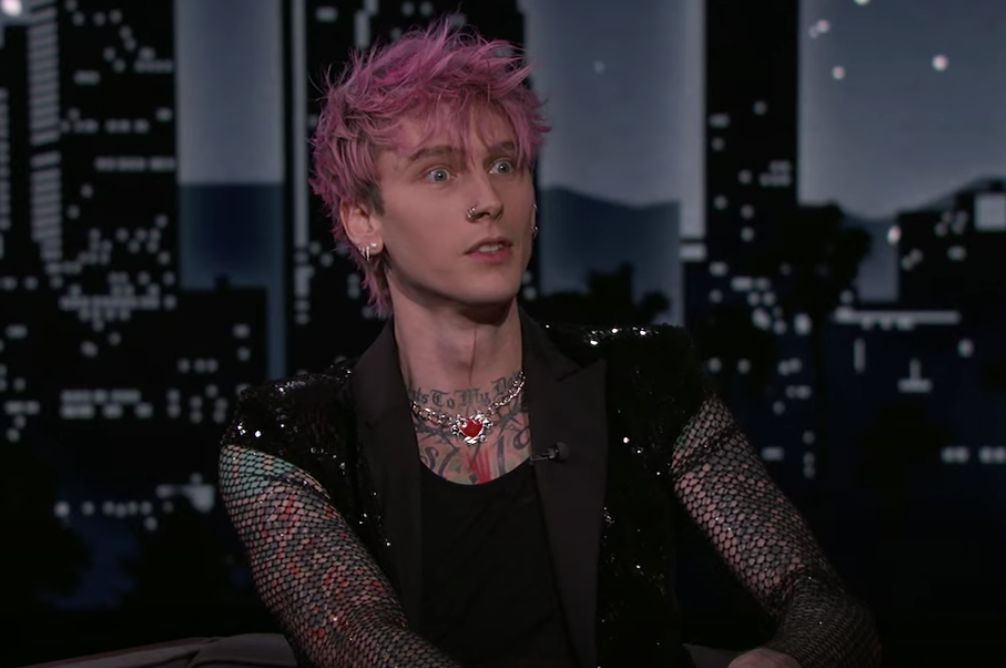 MGK in a mesh jacket and shocked expression while talking on the late night show