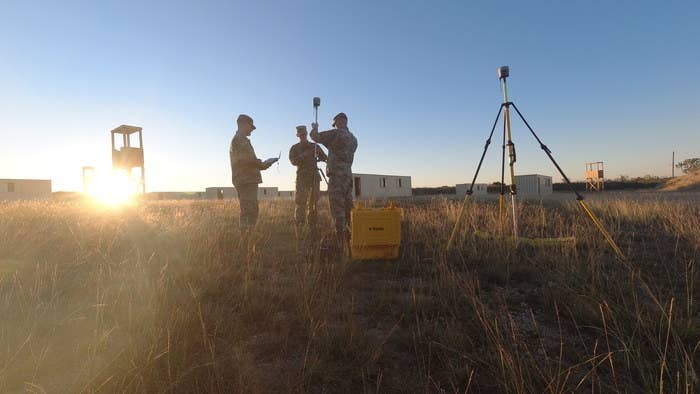 Three technical engineers using survey equipment at a site
