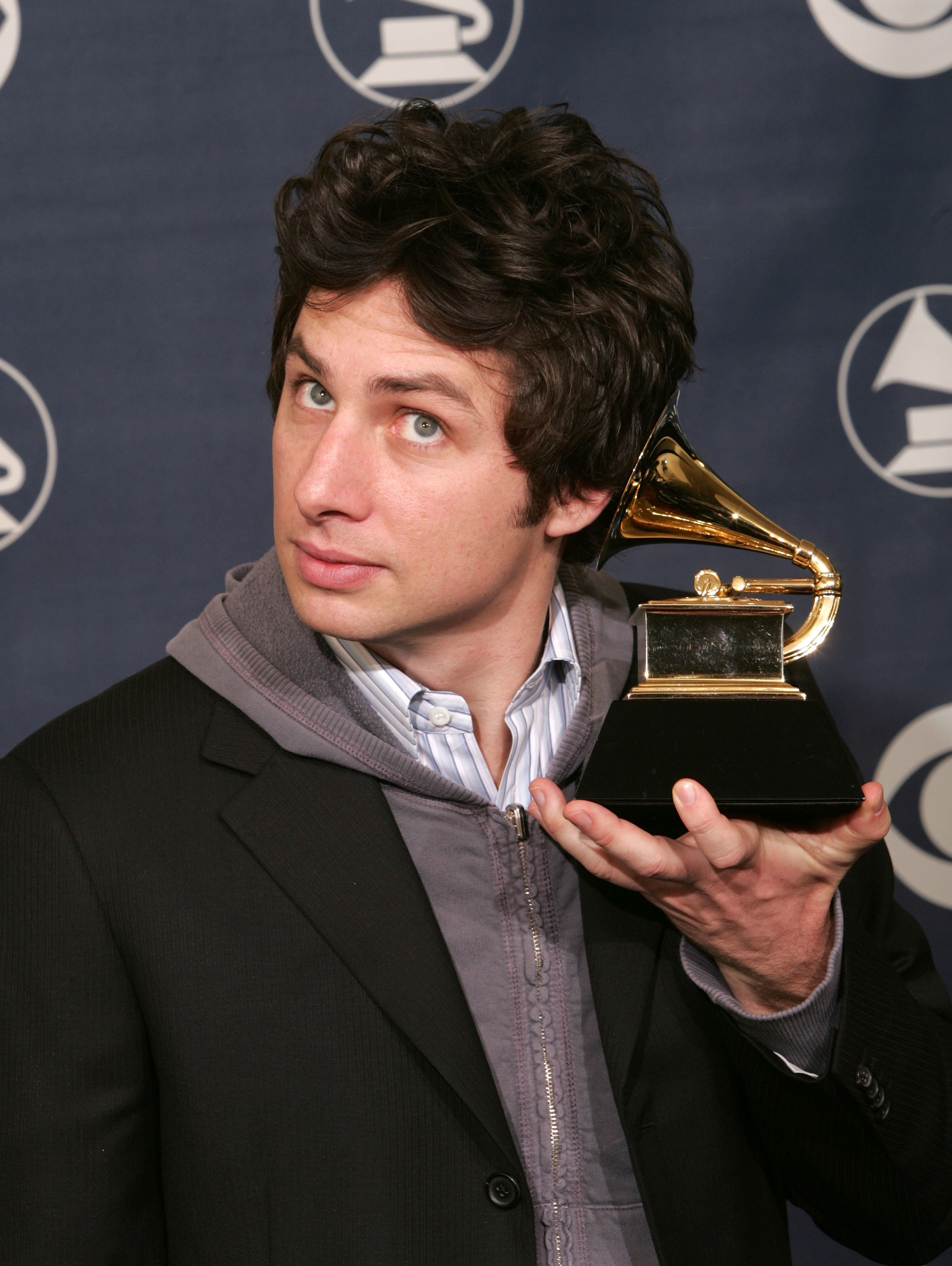 Zach Braff holds his award to his ear like a seashell