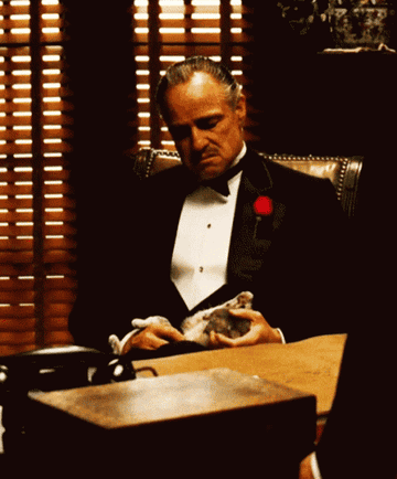 Scene from Godfather where mafia boss Don Vito Corleone is giving brutal orders while petting a cat