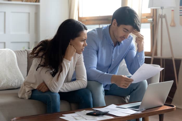 A couple sit at their coffee table to go over financials