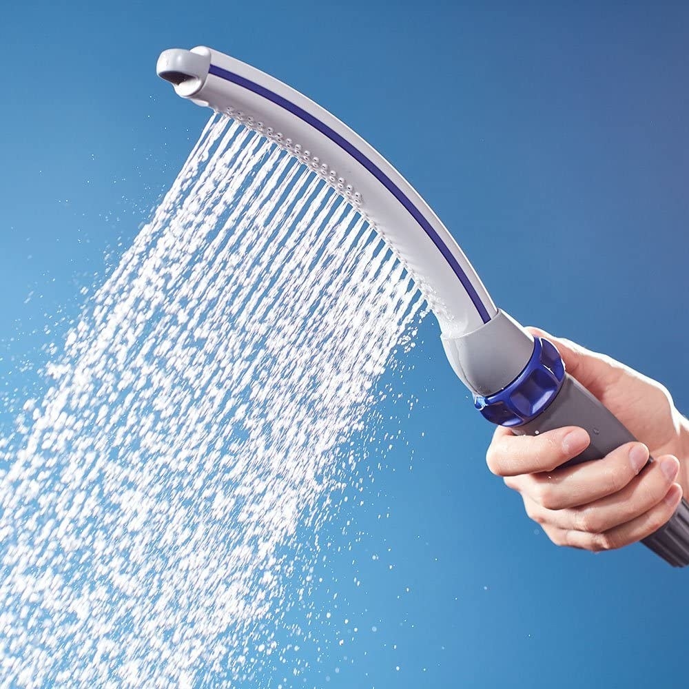 a close up of the comb-like shower head spraying water