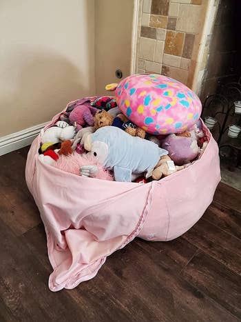 A pile of stuffed animals inside the bean bag cover