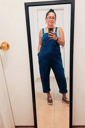 a reviewer wearing the overalls in blue