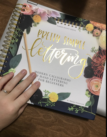 Reviewer holding the spiral bound book on a table