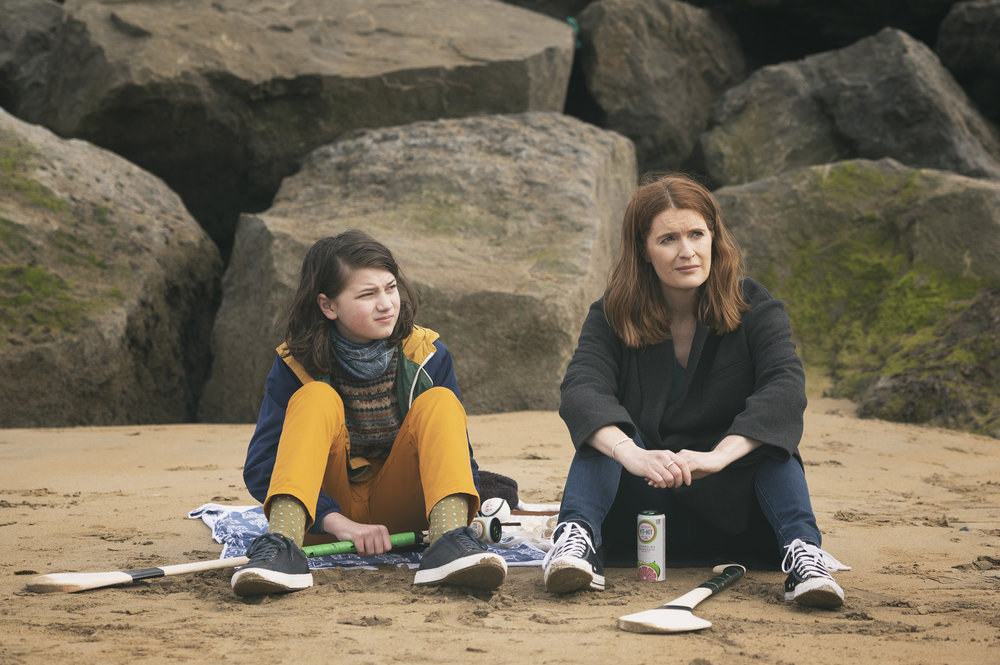 Elijah O&#x27;Sullivan and Justine Mitchell sit on a beach