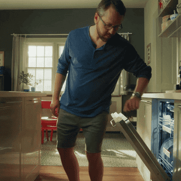 a man using his butt to close the dishwasher