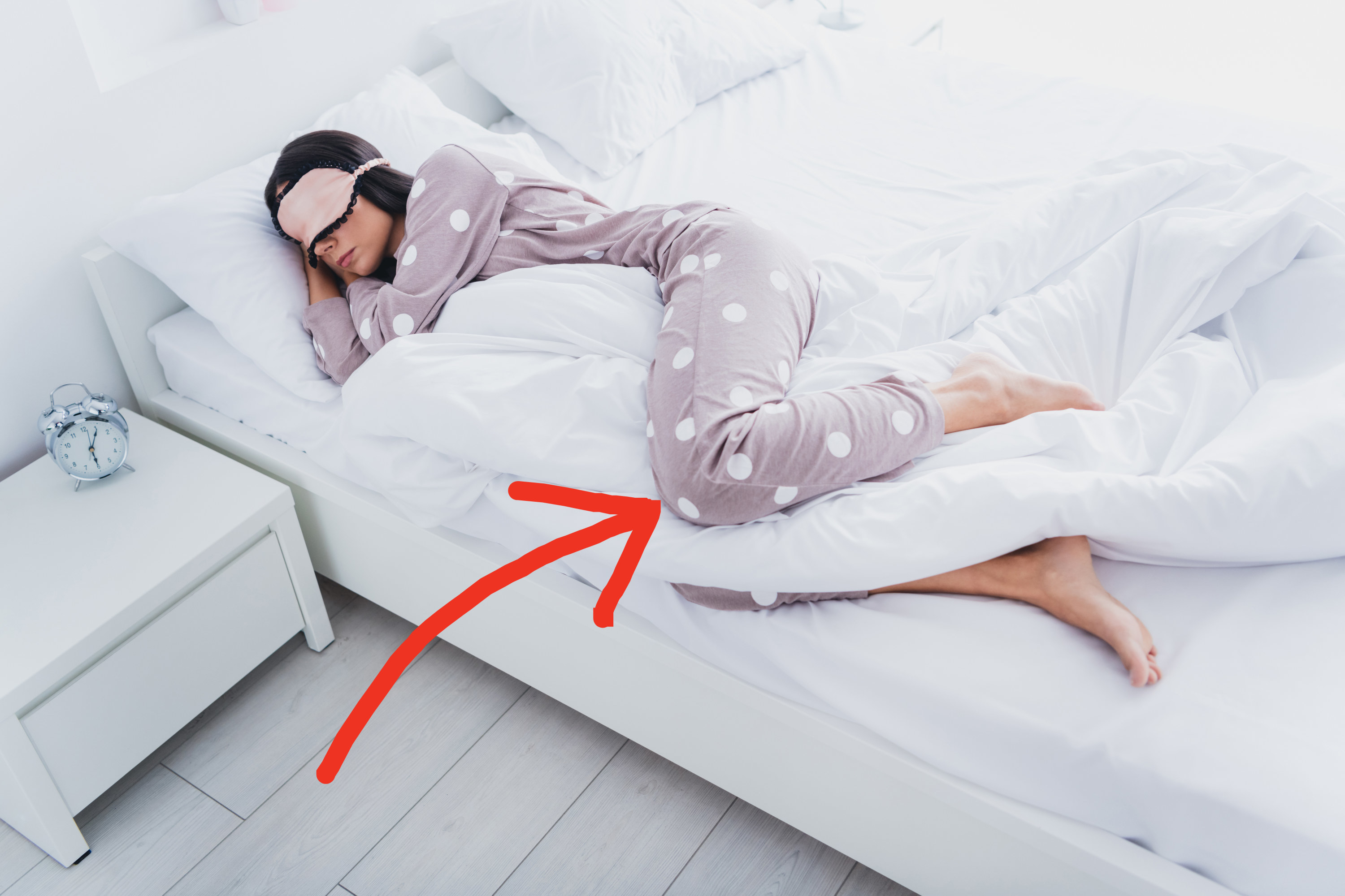 an arrow pointing to someone&#x27;s pillow in between their legs as they sleep on their side