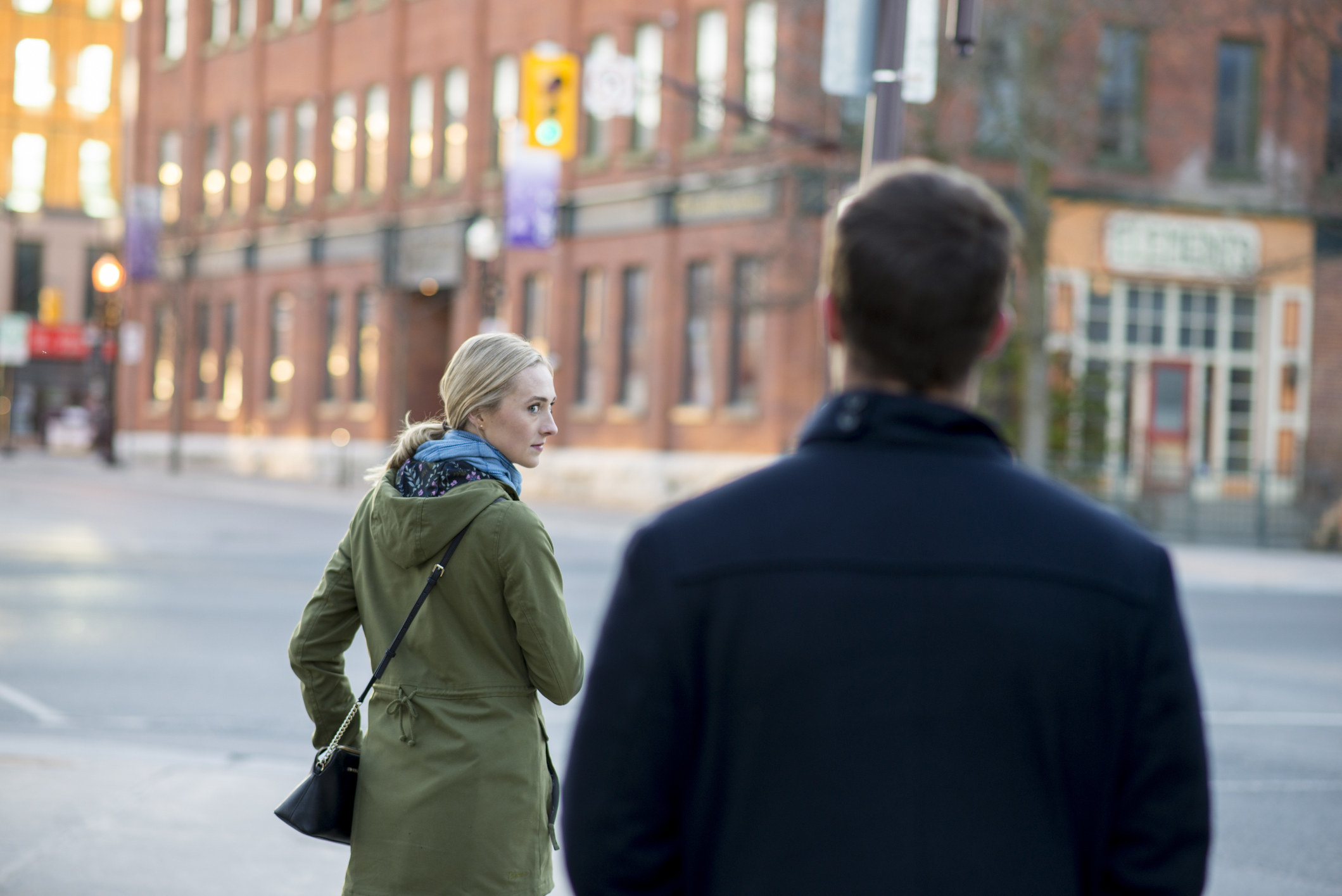 Woman looks back over shoulder at a man following her