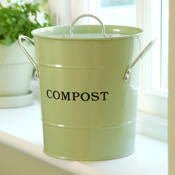 the compost bucket in sage green on a window sill
