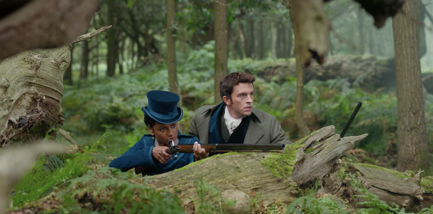 in the dress, Kate ducks behind a tree stump with Anthony as she aims her rifle