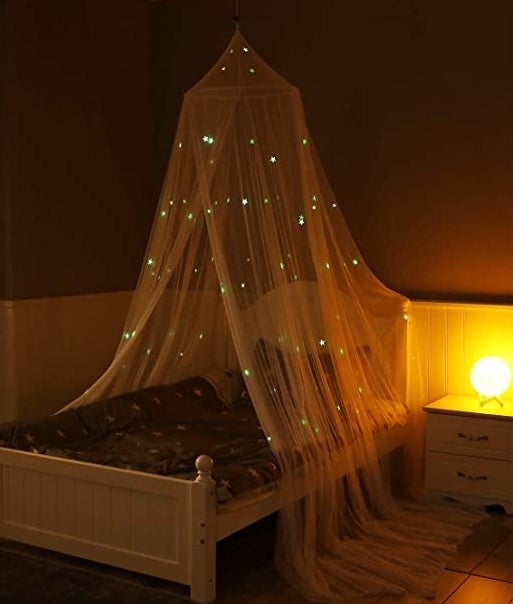 the canopy on a bed with the stars lit up in the dark