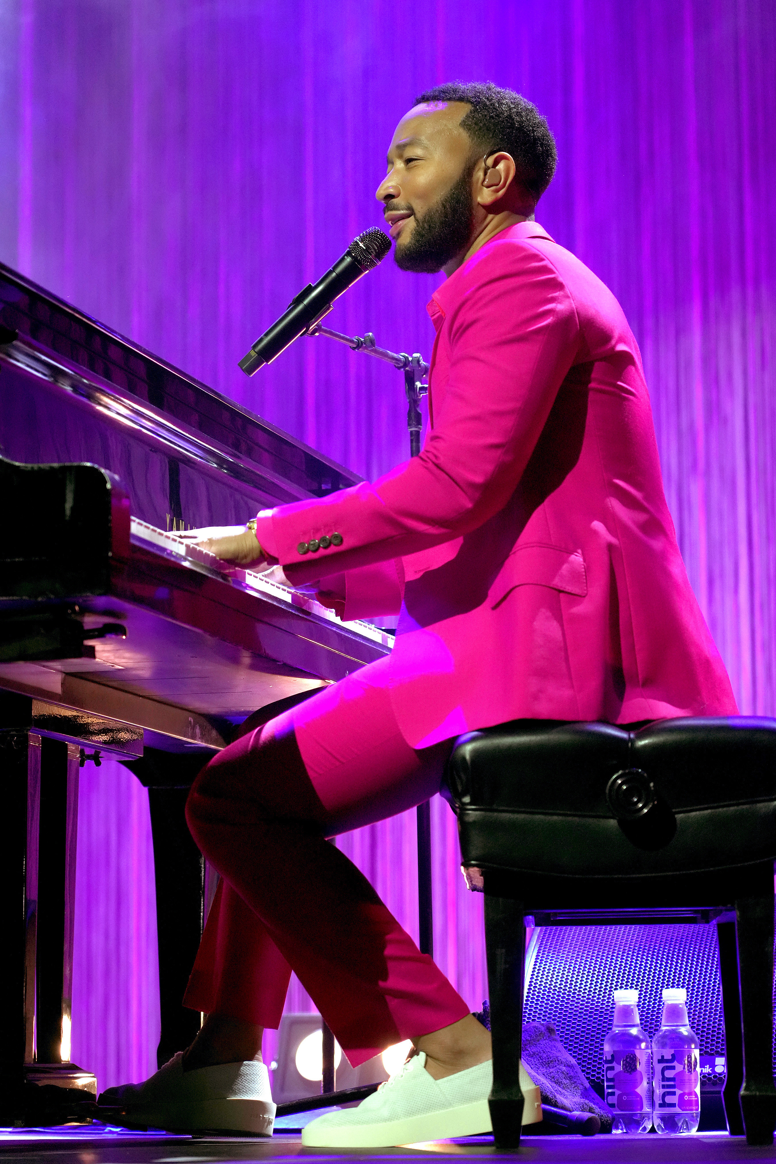 John Legend sings onstage while playing the piano