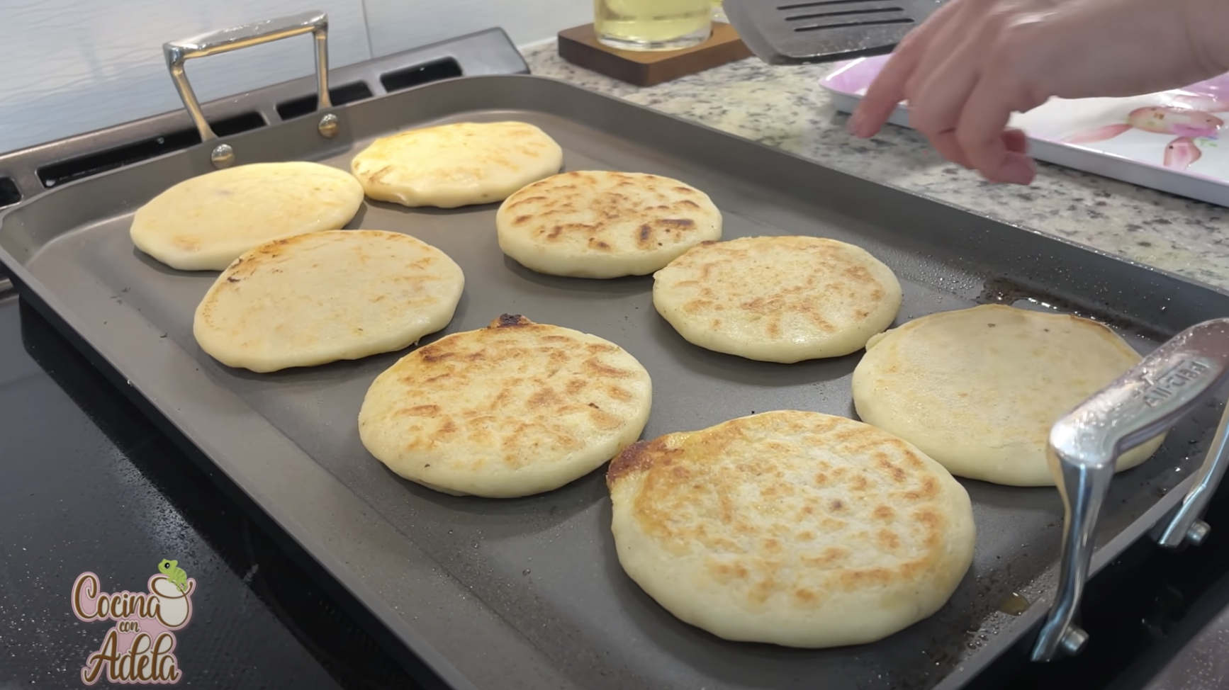 Pupusas cooking on a griddle pan
