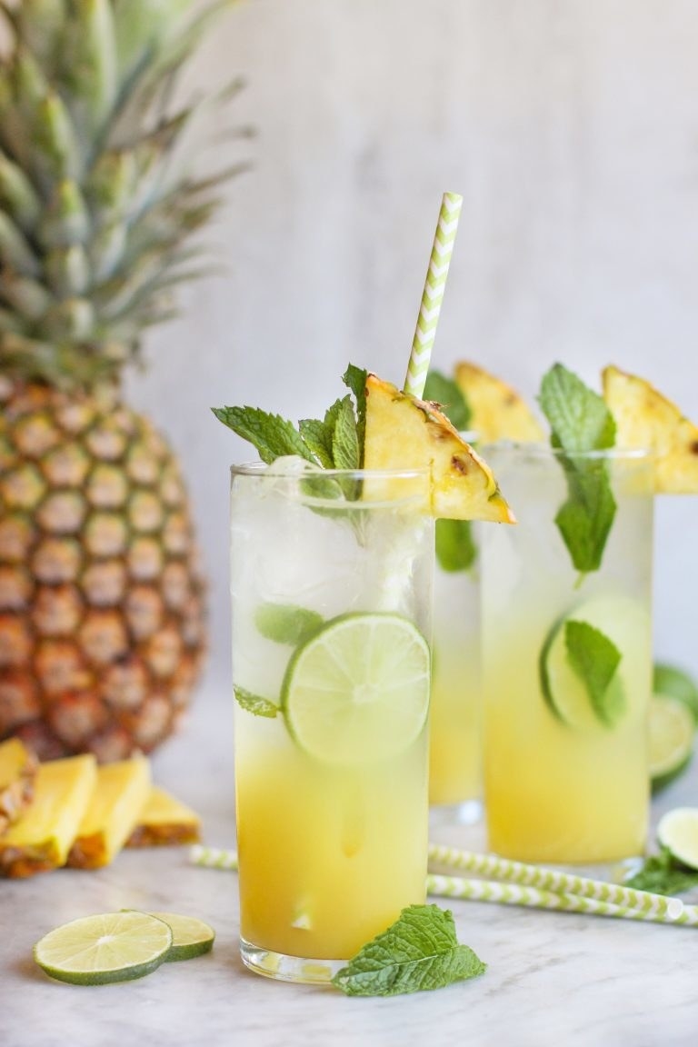 Pineapple, mint, and lime caipirinhas in tall glasses