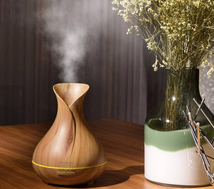 The oil diffuser with steam coming out of it on a table