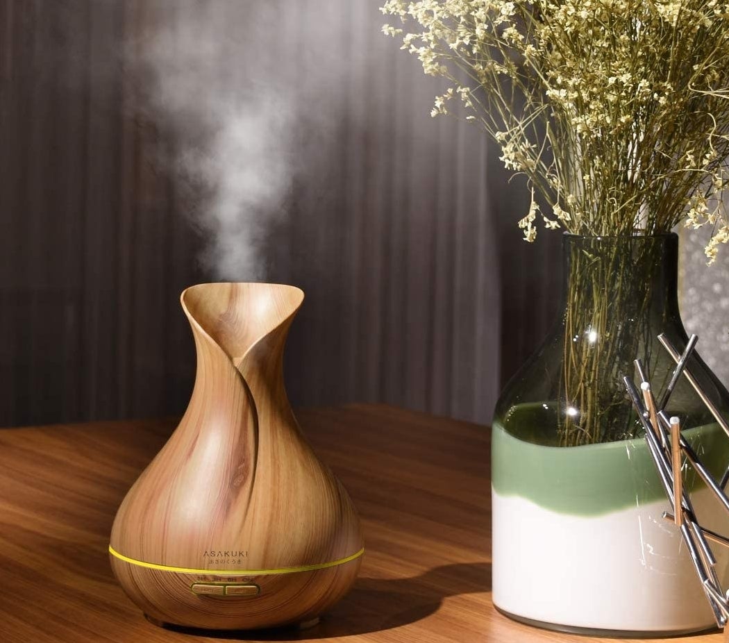 The oil diffuser with steam coming out of it on a table