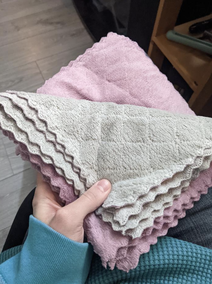 Someone holding a small pile of the microfibre cloths