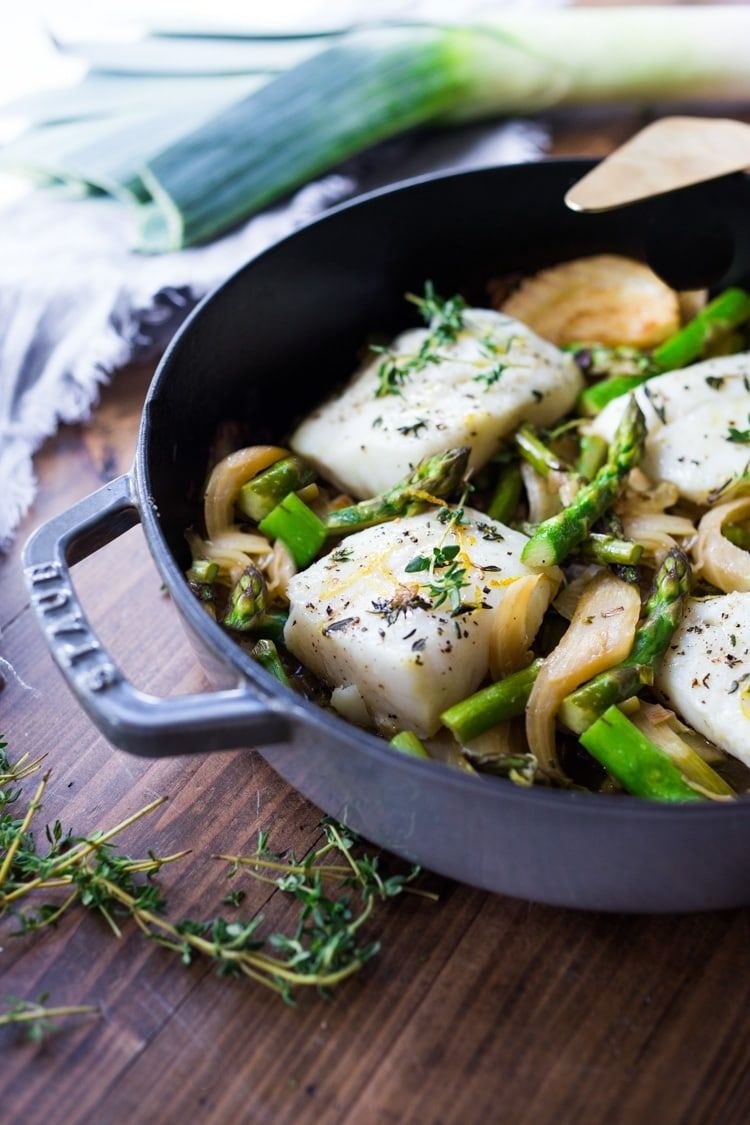 A skillet of cod with asparagus and leeks