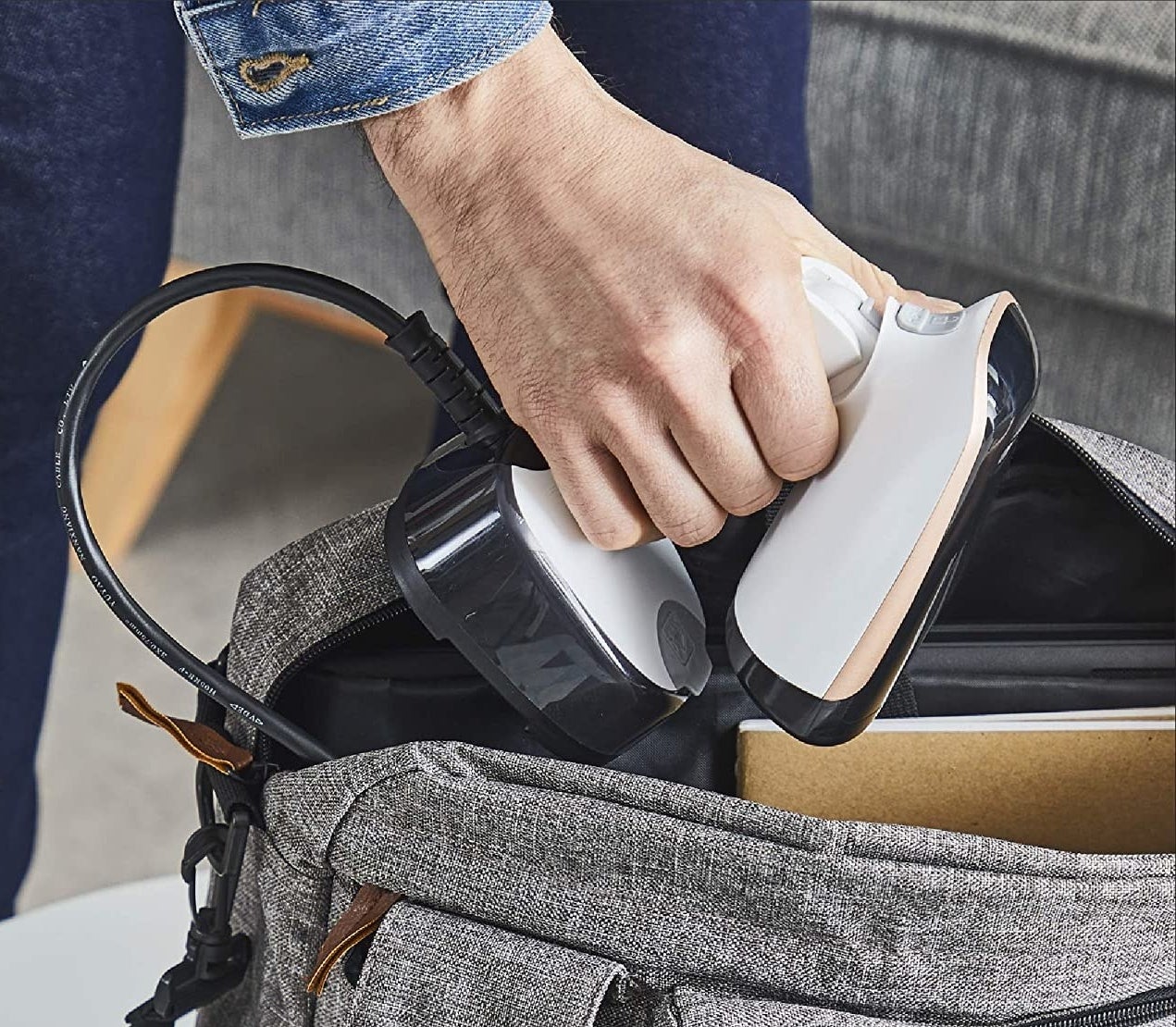 a person putting the folded steamer into their bag